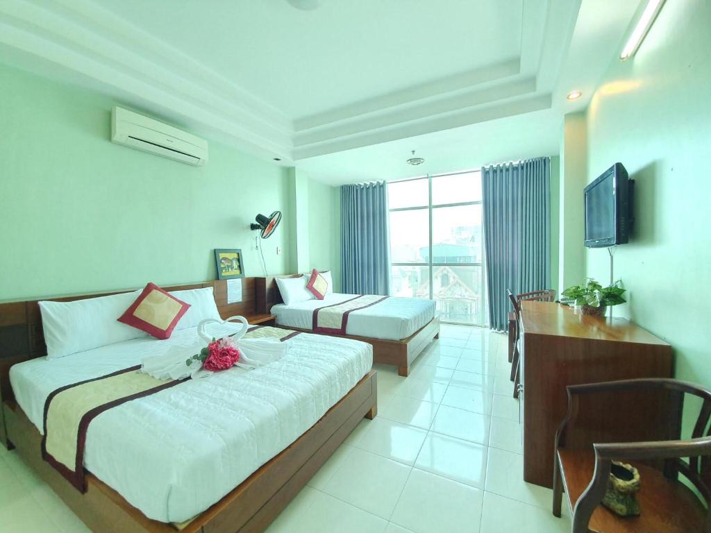 胡志明市Khách sạn Trường Sơn的酒店客房配有床、沙发和电视。