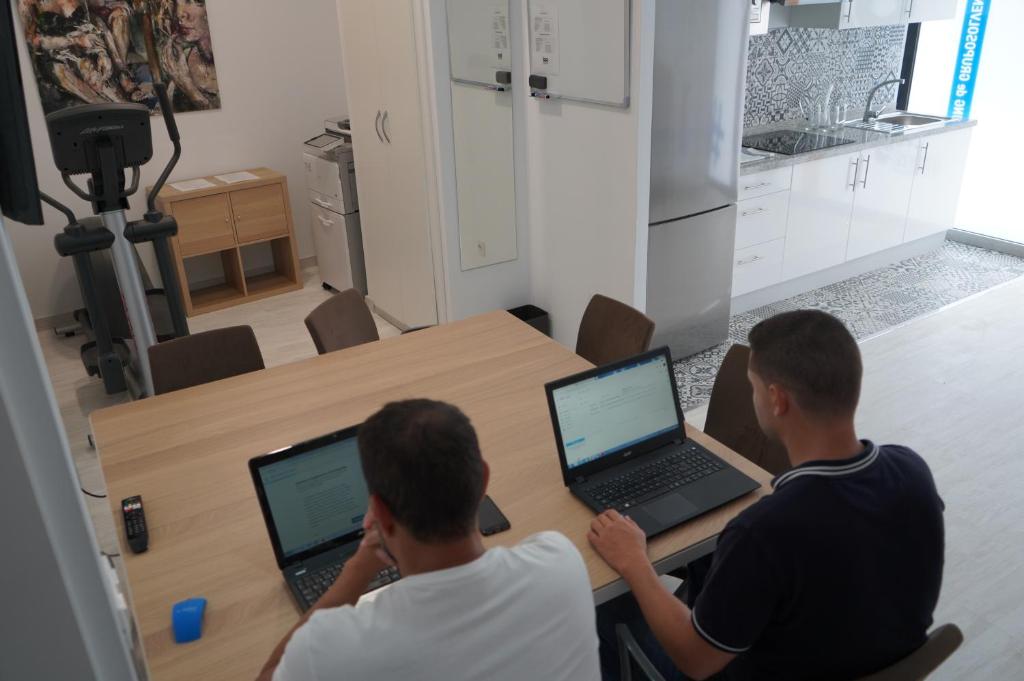 大加那利岛拉斯帕尔马斯Coworking Studio的两个人坐在桌子上,手提电脑