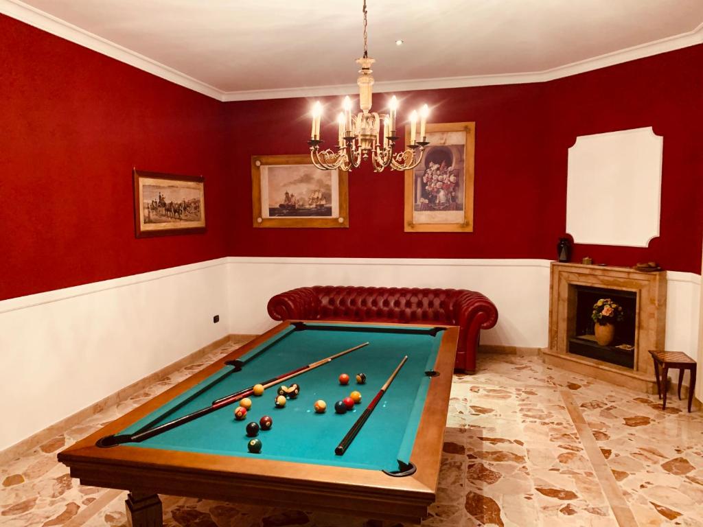 庞贝Chateau Les Jumeaux的红色墙壁的房间里设有一张台球桌