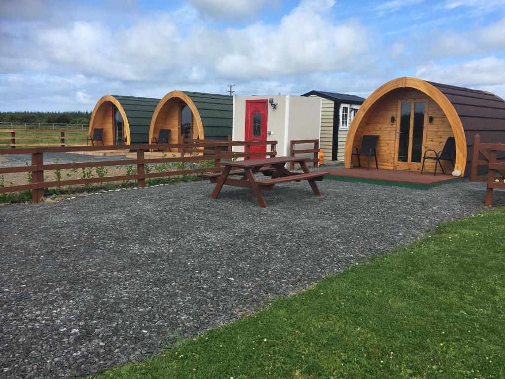 基尔基Emlagh, Self Catering Glamping Pods的一组小屋,配有野餐桌和长凳