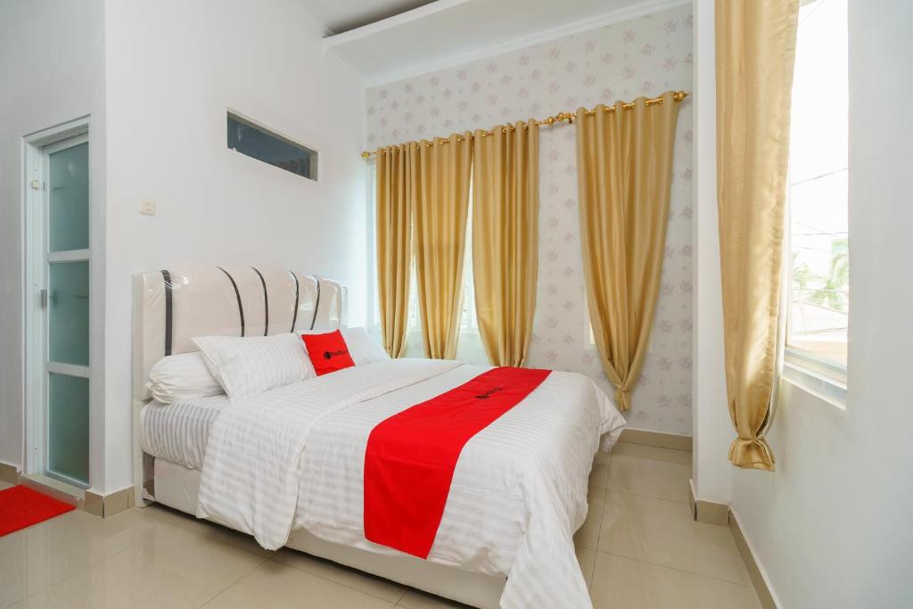 巨港RedDoorz Syariah near Simpang Sekip Palembang的一间卧室配有一张带红白毯子的床