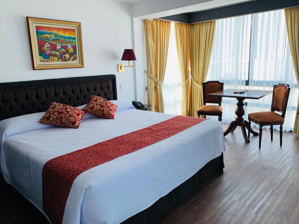 利马蒙特里尔酒店的酒店客房,配有一张床和一张桌子及椅子