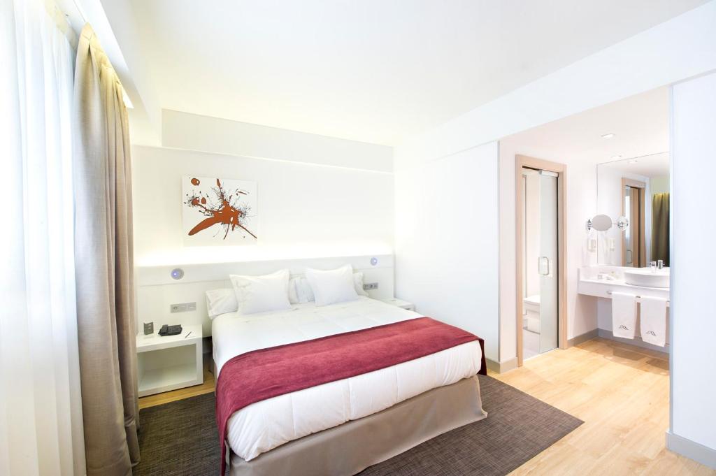 米兰达德埃布罗塞尔科蒂尔城·德米兰达酒店的白色的卧室设有一张大床和一间浴室。