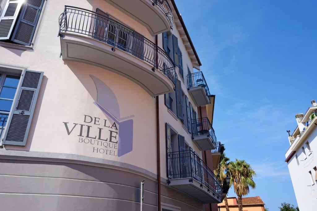 莱圭利亚Boutique Hotel de la Ville的一座带有读取 del la ville精品酒店标志的建筑