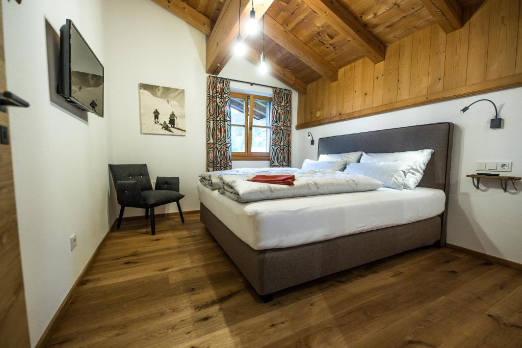 菲伯布伦Leni´s Appartements的一间带一张大床的卧室,位于一个拥有木制天花板的房间