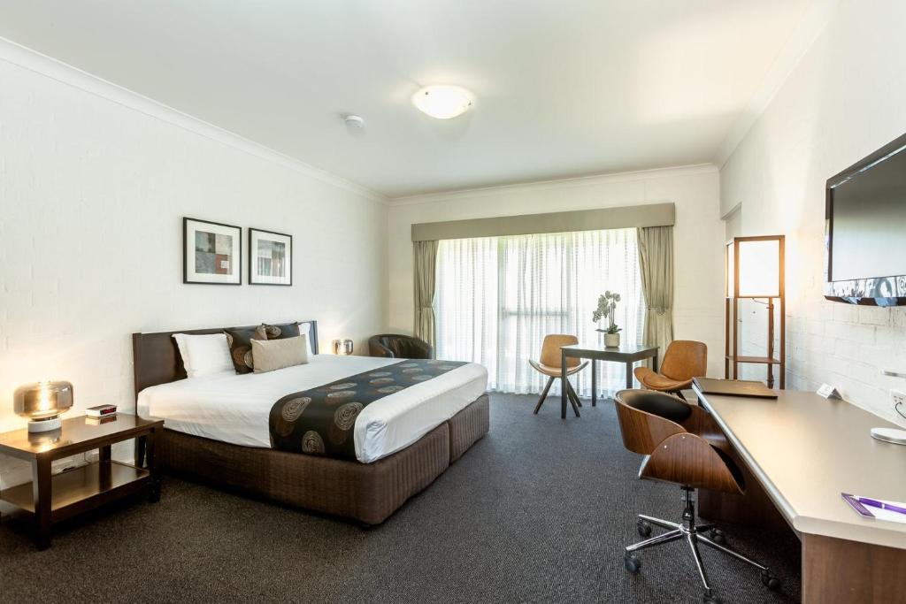 沃东加布雷兹因斯顿普汽车旅馆及套房公寓式酒店的配有一张床和一张书桌的酒店客房