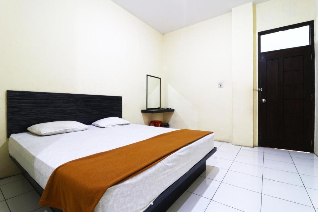 ParitGuest House Taman Sari Syariah的一间卧室设有一张大床和一扇黑色的门