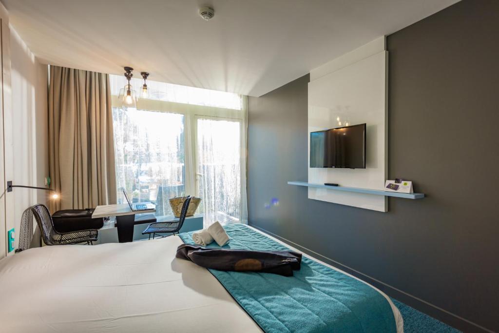 巴拉吕克莱班奥佩拉里亚派斯酒店的一间卧室配有一张床、一张书桌和一个窗户。