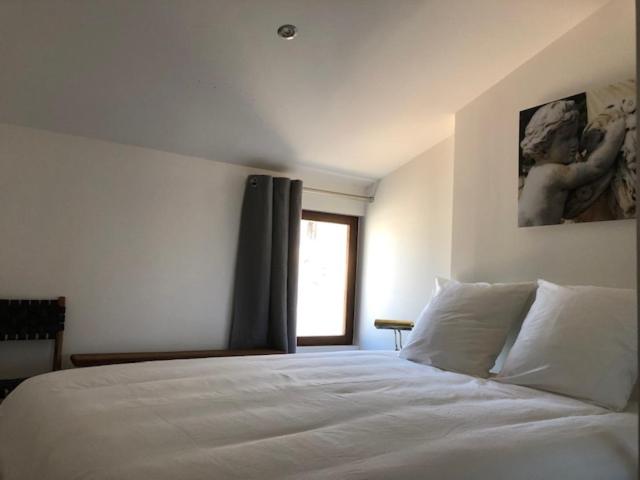 尼姆Appartement avec terrasse panoramique au coeur de Nîmes的卧室配有白色的床和窗户