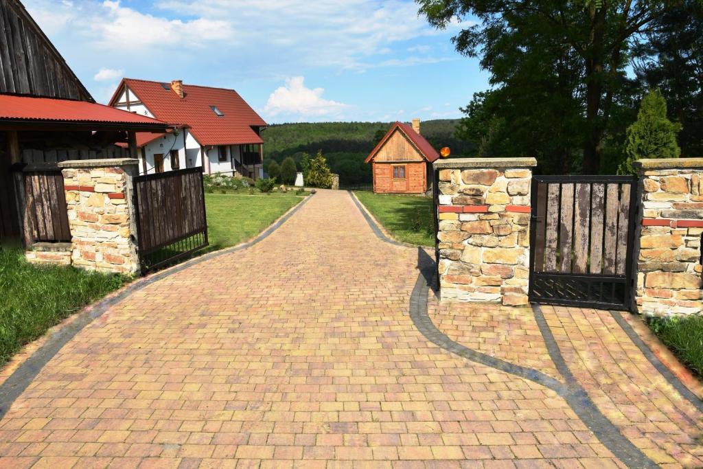 IwaniskaDrewniany domek z piernika的房屋前有两扇门的砖砌车道
