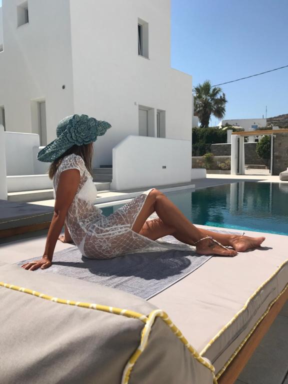 纳乌萨Quartano Luxury Cycladic Residence, Adults Only (13+)的坐在游泳池旁床边的女人