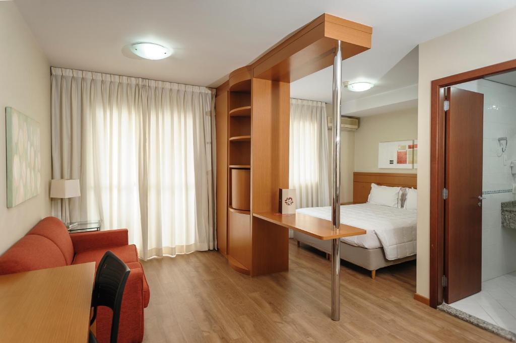 奥萨斯库尊贵酒店的酒店客房配有床、沙发和桌子。