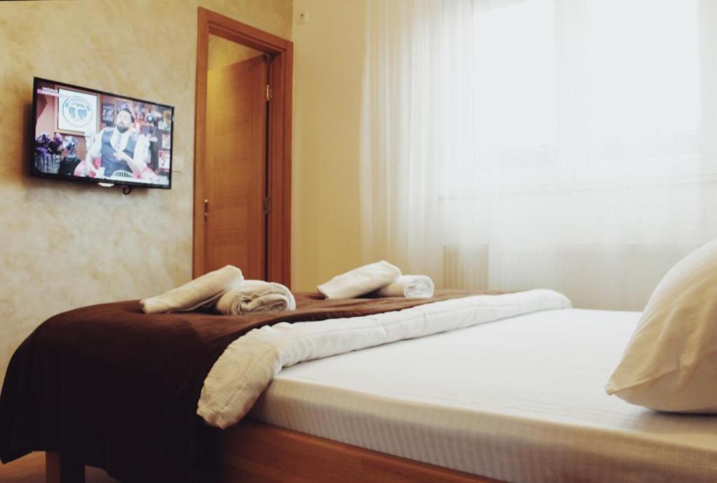 克拉列沃Konačište Simče的一间卧室设有两张床,墙上配有电视。