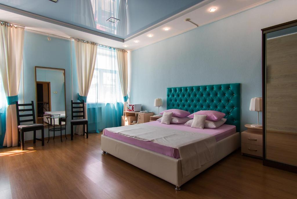 巴尔瑙尔Гостиница Бизнес Турист的一间卧室配有一张大床和蓝色床头板