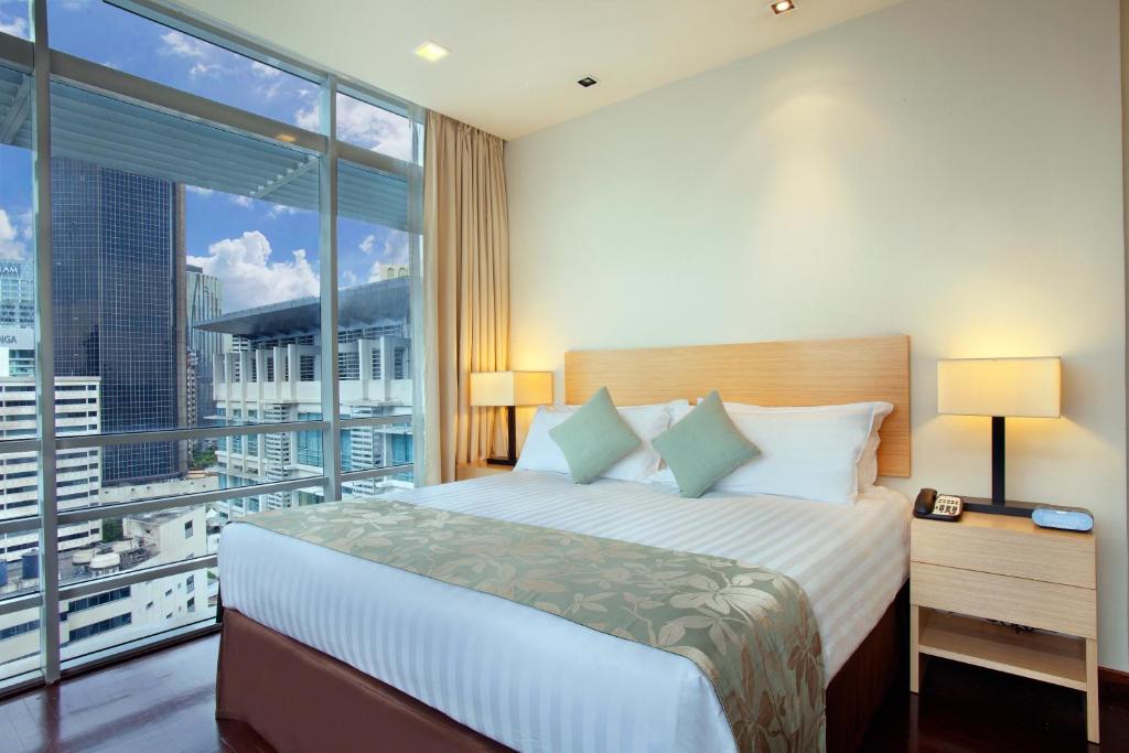 吉隆坡吉隆坡宾乐雅服务公寓的酒店客房设有一张床和一个大窗户