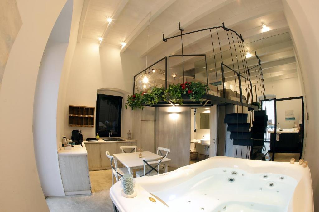 巴列塔Sebèl Luxury Rooms的一间带浴缸和桌子的浴室以及一间厨房
