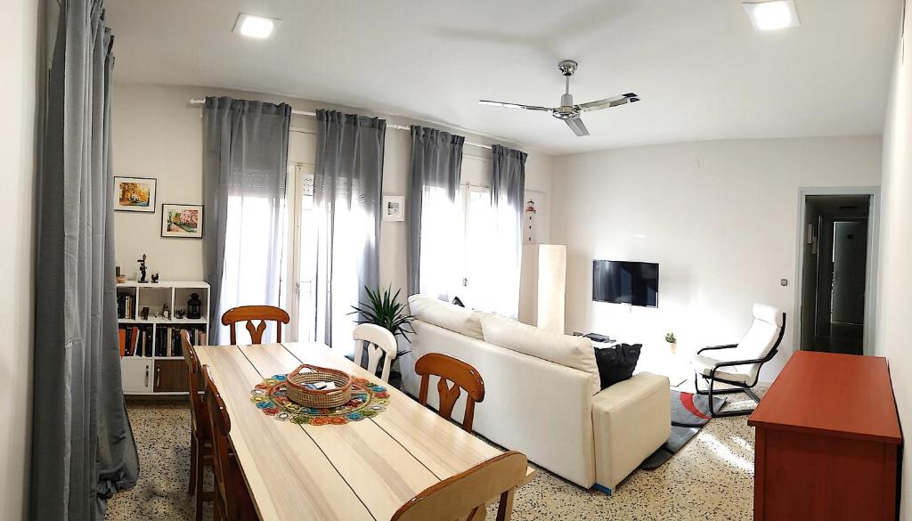 兰卡Piso Familiar en Llançà的客厅配有桌子和白色沙发