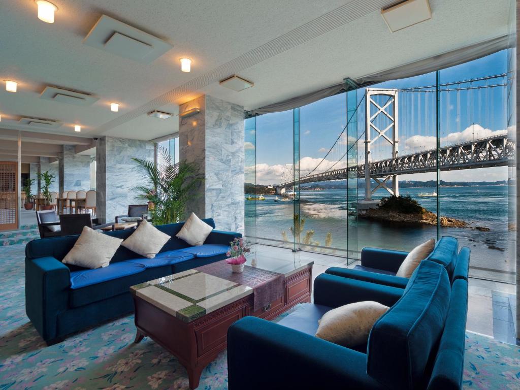 鸣门市鸣门海月酒店的客厅设有蓝色的沙发和一座桥梁