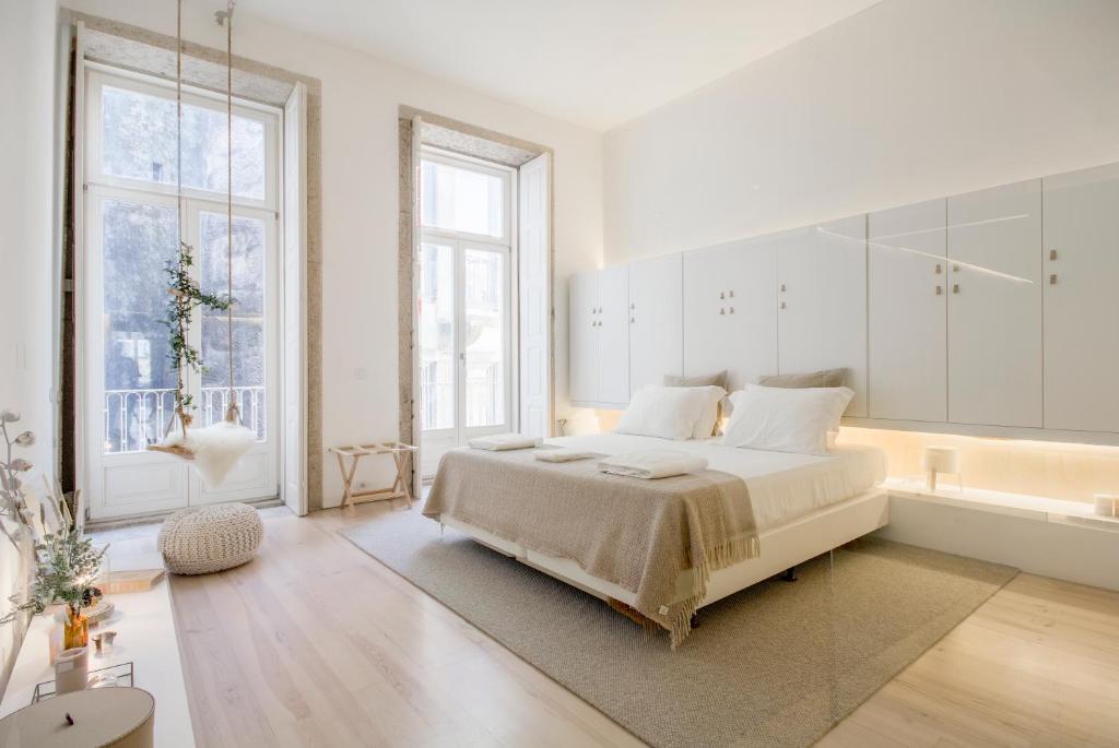 波尔图OHH - Mouzinho Deluxe Apartment的白色卧室设有一张大床和一个浴缸