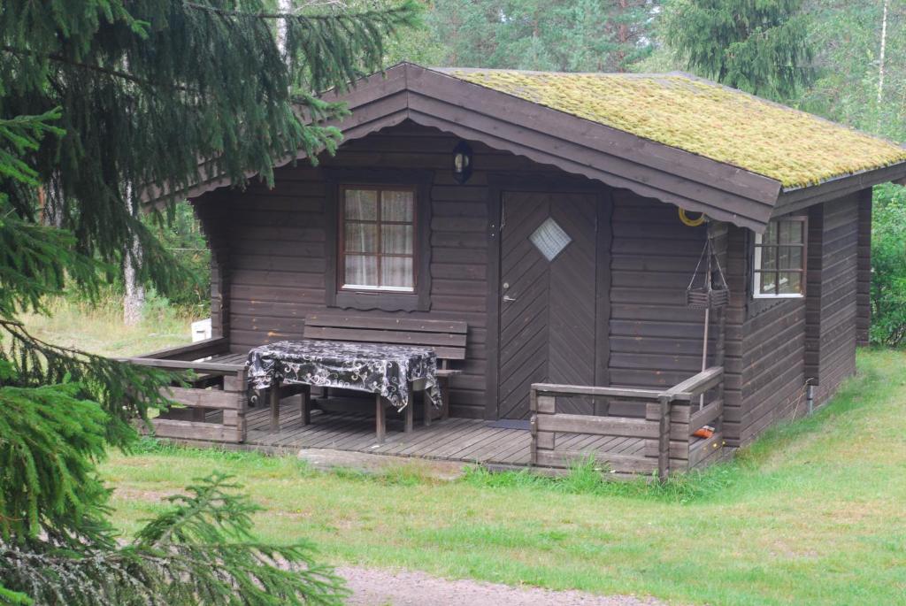 VaggerydLidens Stugby的小屋设有门廊和甲板上的长凳