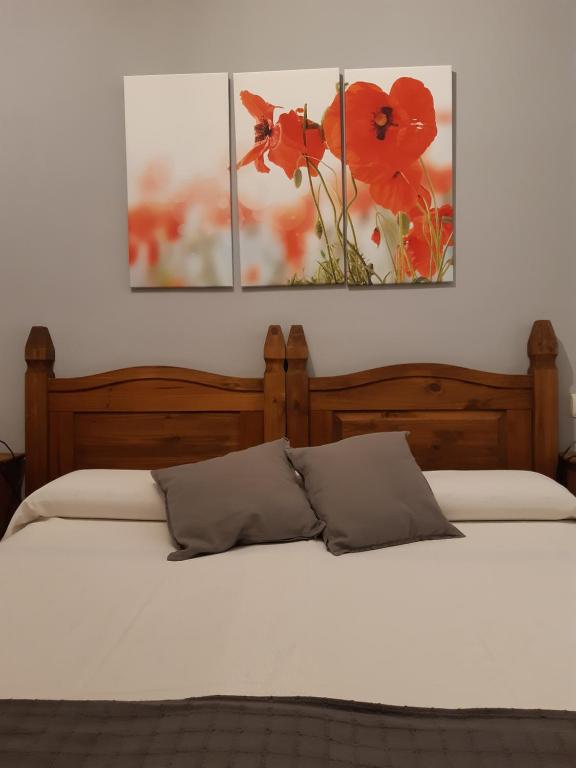 洛萨尔德拉韦拉Hostal El Rincon de la Vera的一间卧室配有两张床,墙上有两幅画作