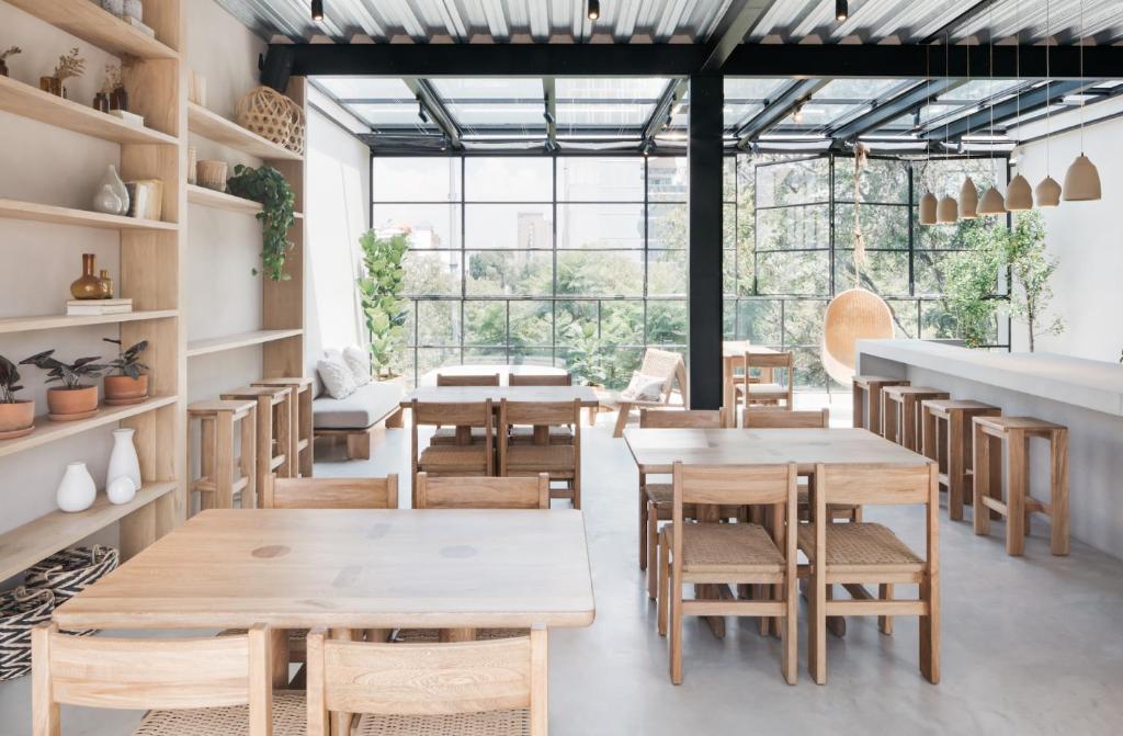墨西哥城Casa Pancha的餐厅设有木桌和椅子以及大窗户。