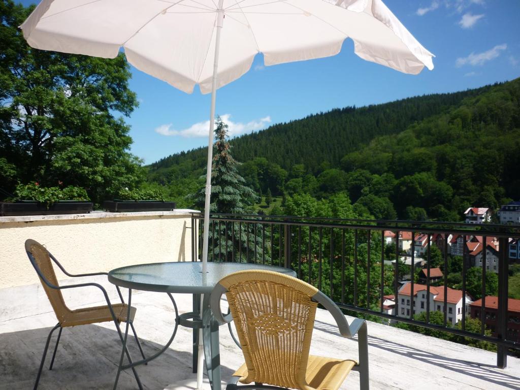 鲁拉瓦尔德胡兹酒店的阳台配有桌椅和遮阳伞