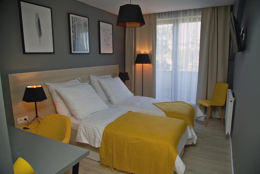 巴尔代约夫B&B ALIBI的一间卧室设有两张床和黄色毯子