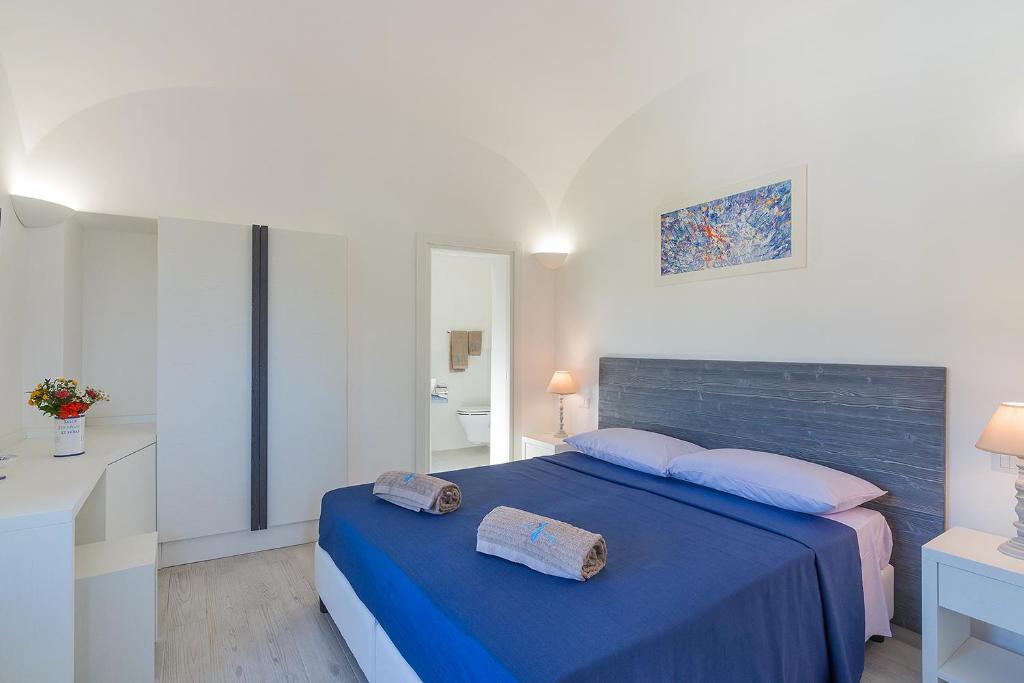 伊斯基亚Nitrodi Thermal Relais的一间卧室配有蓝色的床和2条毛巾