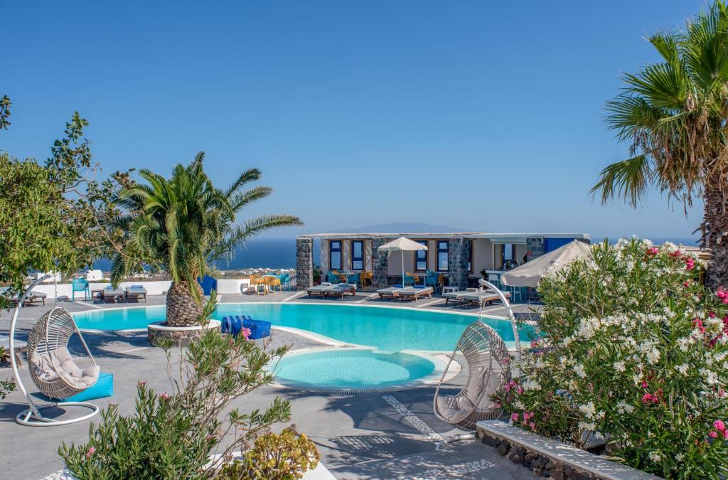 伊亚安尼摩米里洛斯酒店的一个带椅子和棕榈树的大型游泳池