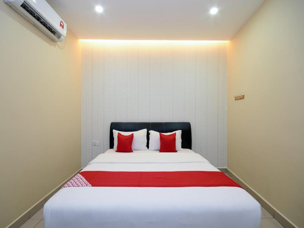 米里OYO 89301 Ys Inn的一间卧室配有一张带红色枕头的大床