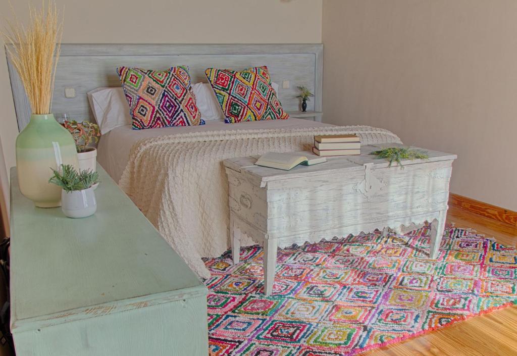 阿雷纳斯德圣佩德罗Sabina Hotel的一间卧室配有一张床和一张桌子及书籍