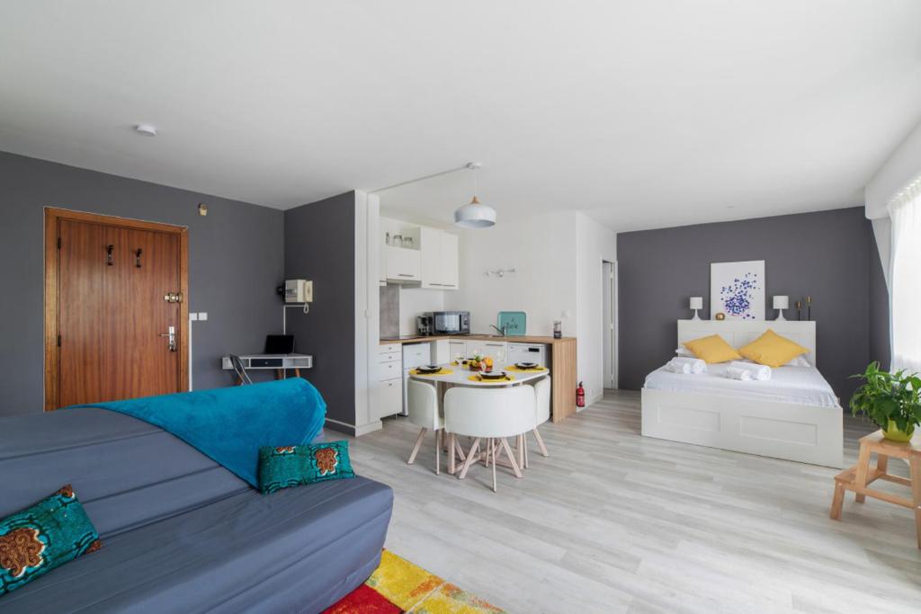 维勒班Nice studio with balcony and parking in Villeurbanne near Lyon - Welkeys的一间带蓝色沙发的客厅和一间卧室