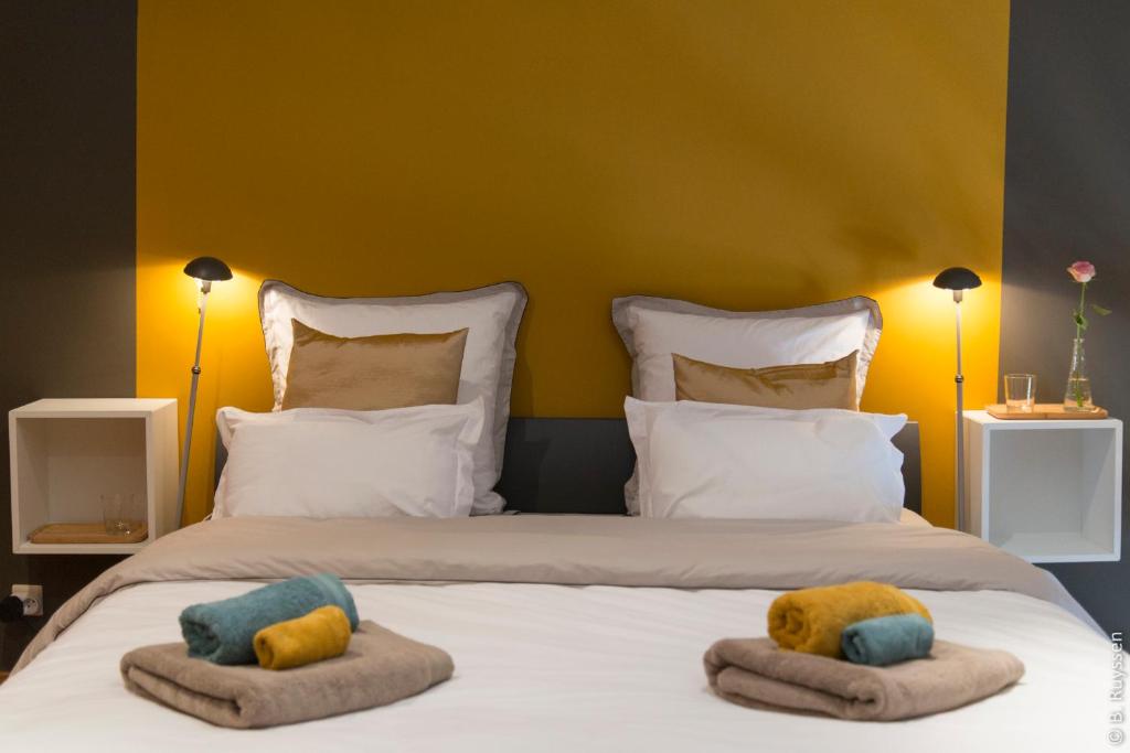 FlavionLes Petits Secrets de Nonna-Chambre d hote dinant的一间卧室配有一张带两个枕头的床