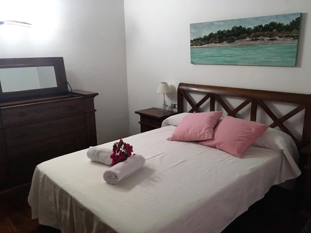 休达德亚Villa para 6 con piscina privada.的一间卧室配有带粉色和白色枕头的床