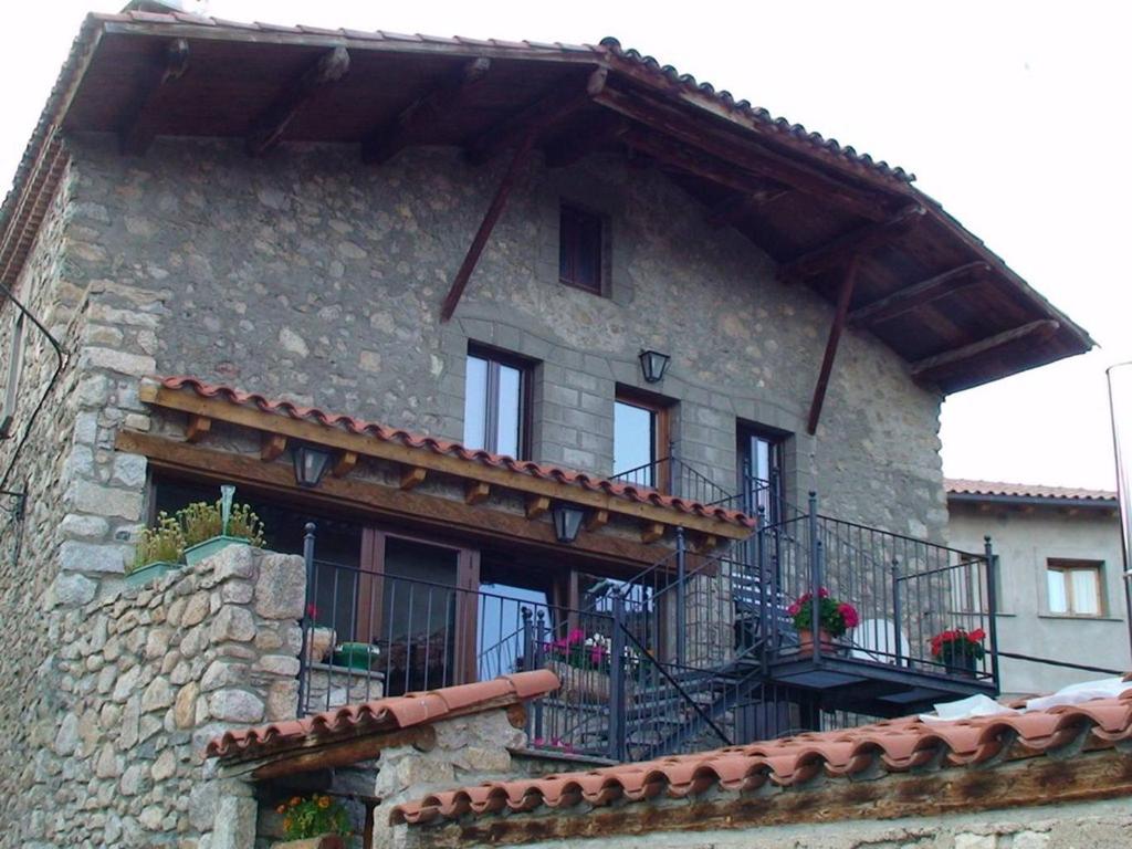 Aransá卡尔桑迪克酒店的石头建筑,带有鲜花阳台
