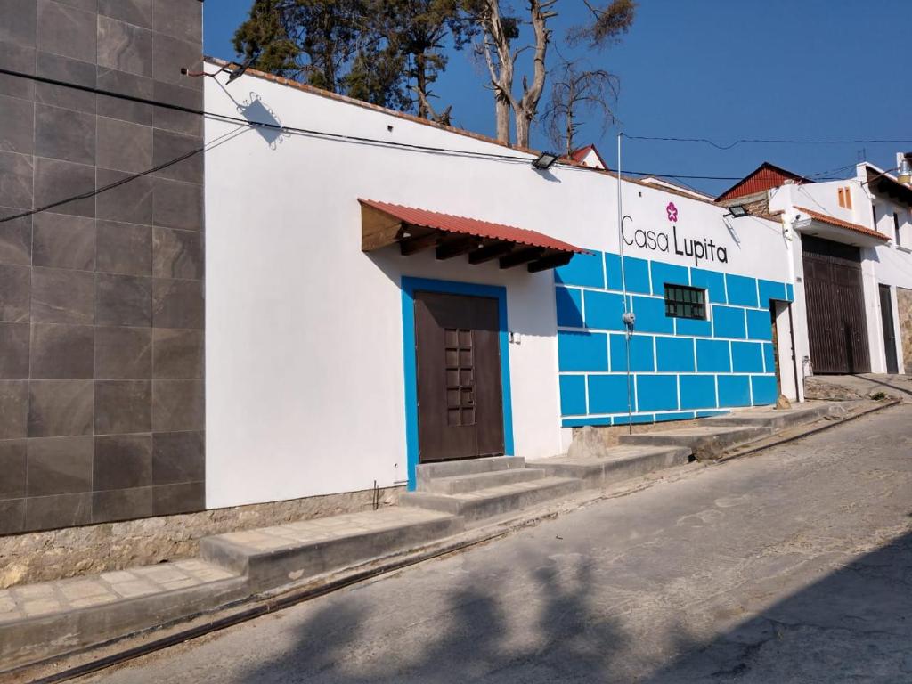 米内拉尔德尔蒙特CASA LUPITA的街道边的蓝色和白色建筑