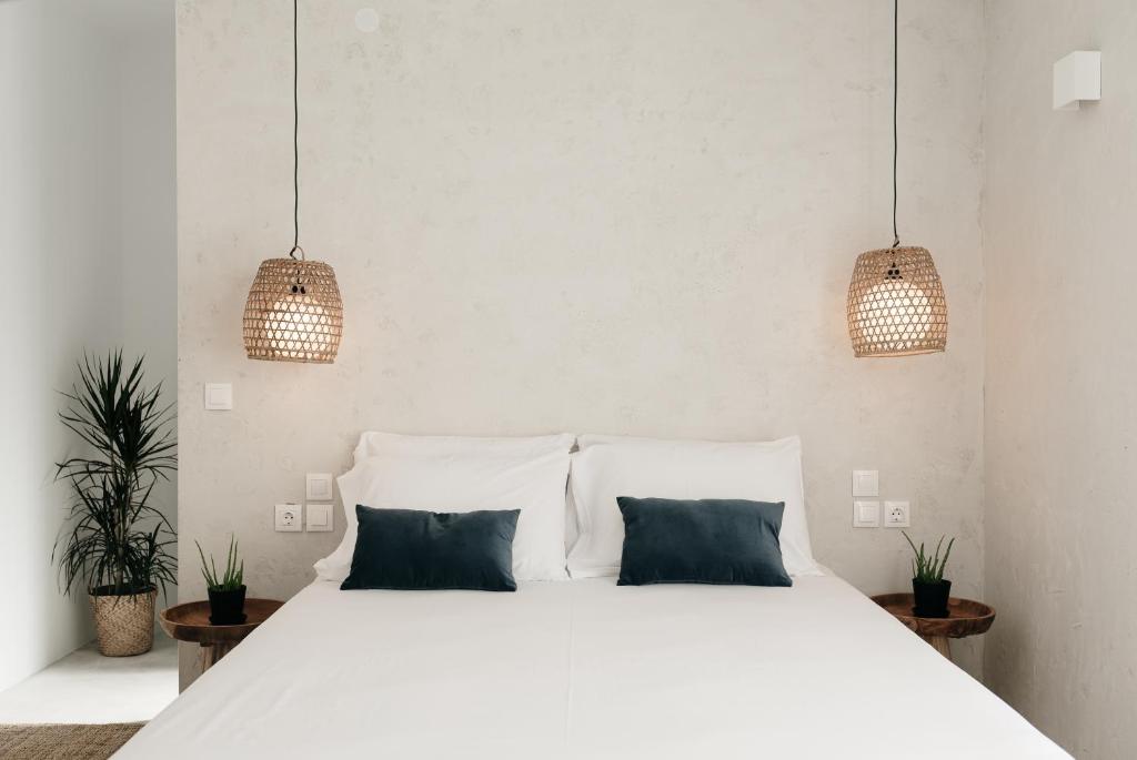 雷夫卡达镇Bohèmian Boutique Hotel Lefkada的一间卧室配有白色的床和2个蓝色枕头