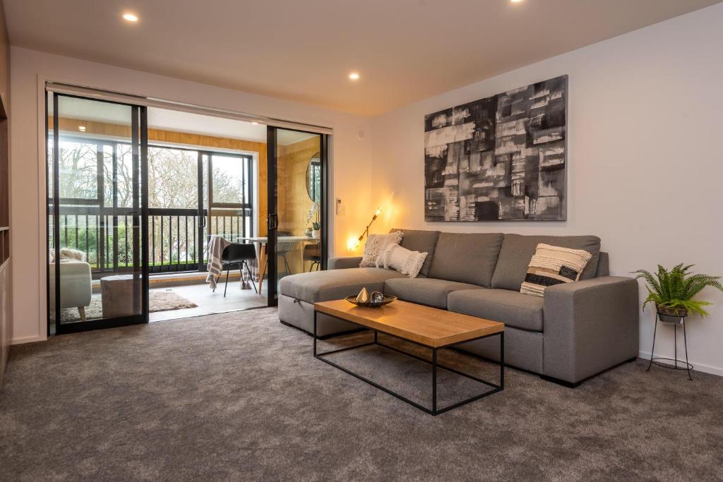 基督城Penthouse with Park View的客厅配有沙发和桌子