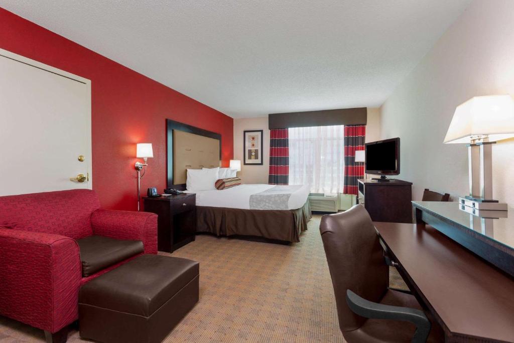 梅肯梅肯温德姆集团温盖特酒店的酒店客房配有一张床、一把椅子和一张书桌