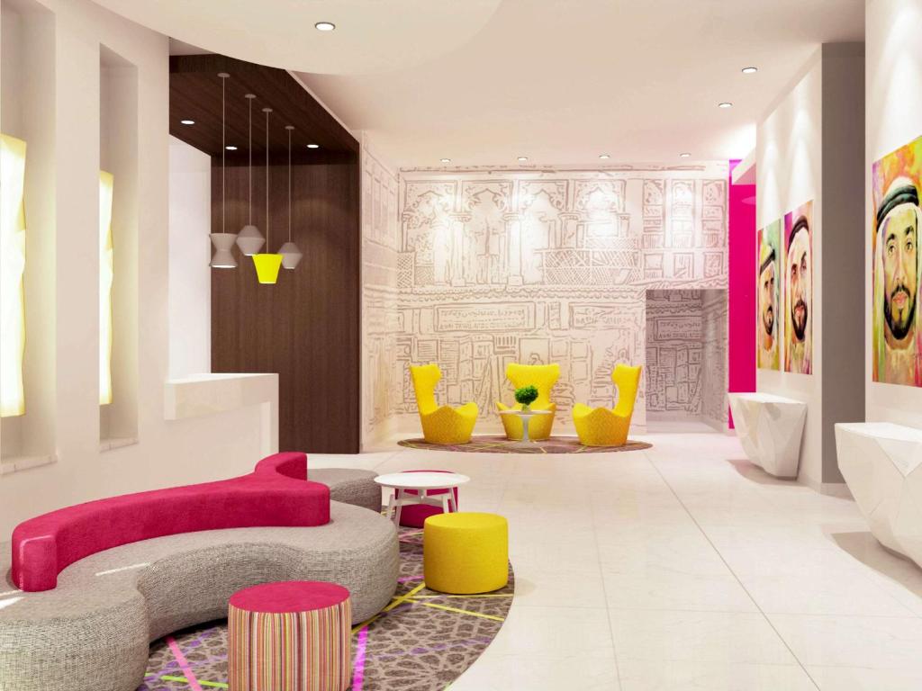 沙迦ibis Styles Sharjah的客厅配有粉红色的沙发和黄色的椅子