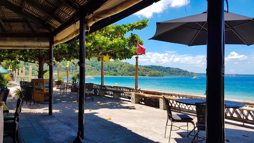 奥隆阿波Playa Papagayo Beach Inn的海滩上一张带遮阳伞的桌子