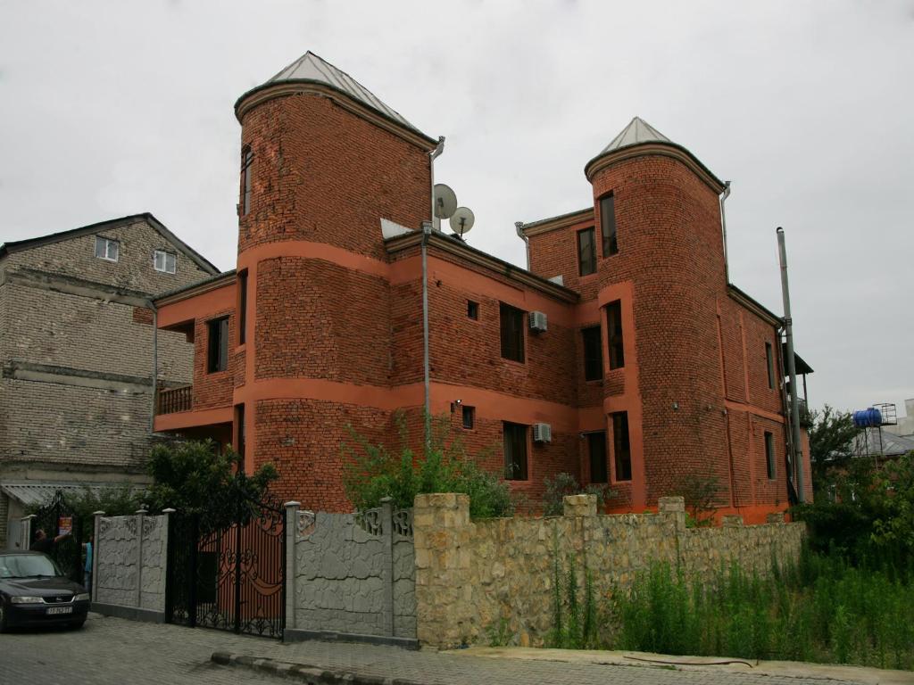 库塔伊西Two Towers Guest House的一座大型红砖建筑,有两个塔