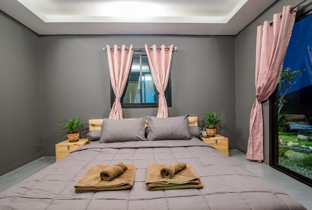 华欣Hua Hin Lae I Aoon的一间卧室配有一张大床和两条毛巾