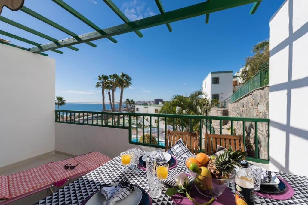 圣巴托洛梅EXCLUSIVES 2-ROOM APARTMENT TOPLOCTAION 5 minutes to beach San Agustin的阳台设有一张桌子,享有海景。