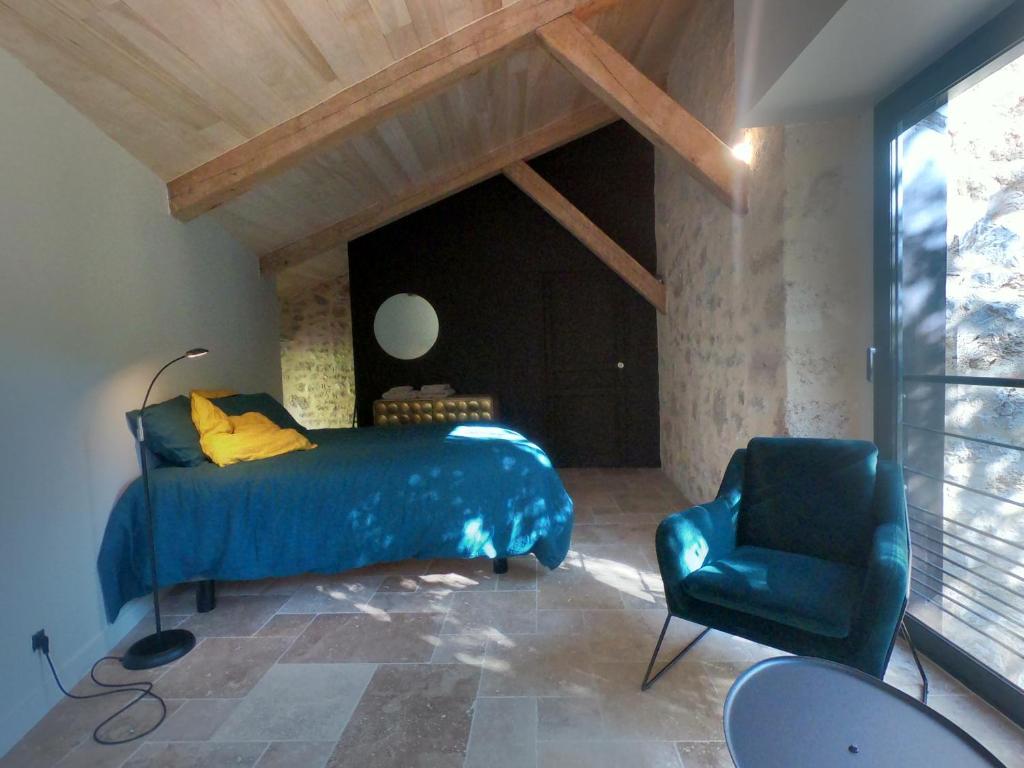 CabreretsLes Jardins Sauvages的一间卧室配有蓝色的床和椅子