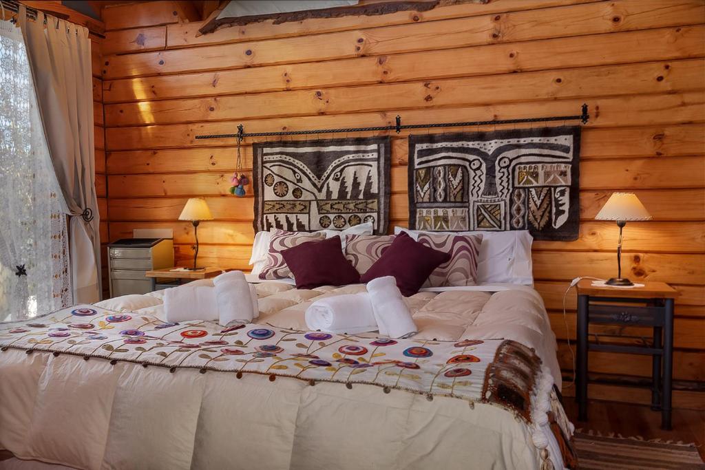 佩休尼亚镇Cabañas Bahiamia的小木屋内一间卧室,配有一张大床