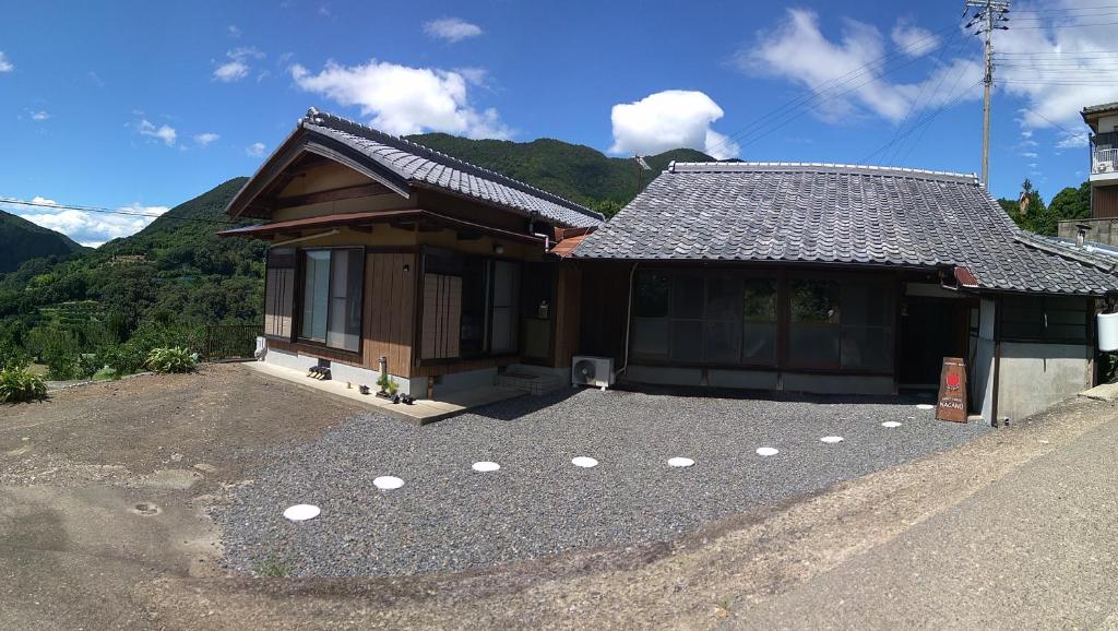 田边市Kumano Kodo Nagano Guesthouse的前面有一大堆碎石的房子