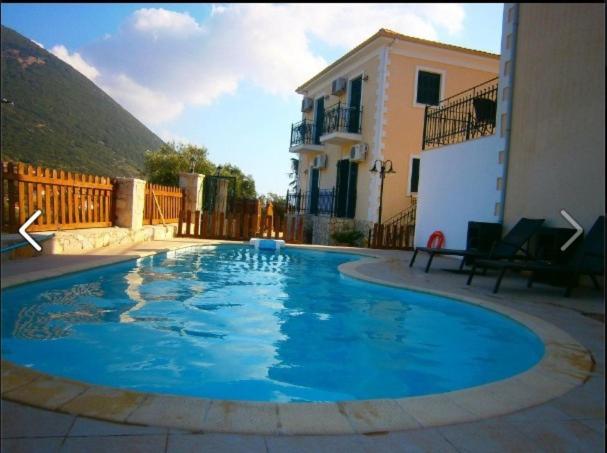 Stavros伊利亚那乡村旅馆的一座大蓝色游泳池,位于房子前