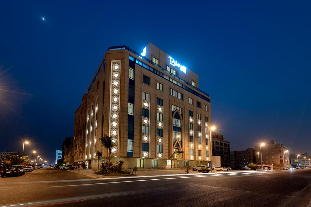 吉达Taj Jeddah Hotel Apartment的一座晚上有灯的建筑